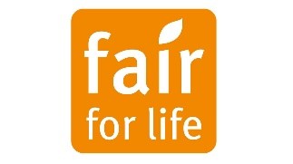 Siegel "Fair for life", weiße Schrift auf orangefarbenem Hintergrund, der I-Punkt ähnelt einem Planzenblatt