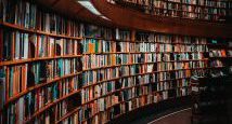 Geschwungene Bücherregale aus dunklem Holz voller Bücher